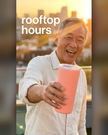 Influencer photo: a man raising a tumbler on a sunlit rooftop