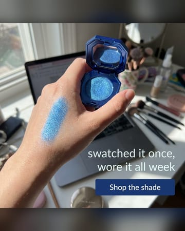 UGC photo: a hand holding glitter eyeshadow at a messy vanity