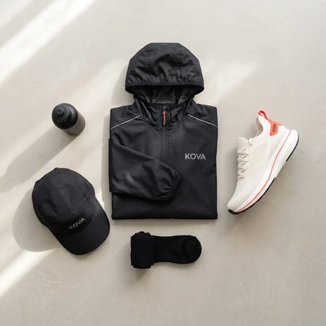 Flat lay of jacket, shoe, cap, socks and bottle on concrete