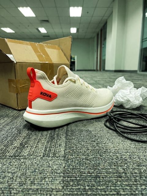 Phone photo of a shoe sample on office carpet beside a box