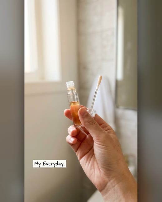 UGC photo: a lip oil held up in a real bathroom