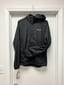 Phone photo of a black running jacket on a wire hanger