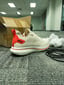 Phone photo of a shoe sample on office carpet beside a box
