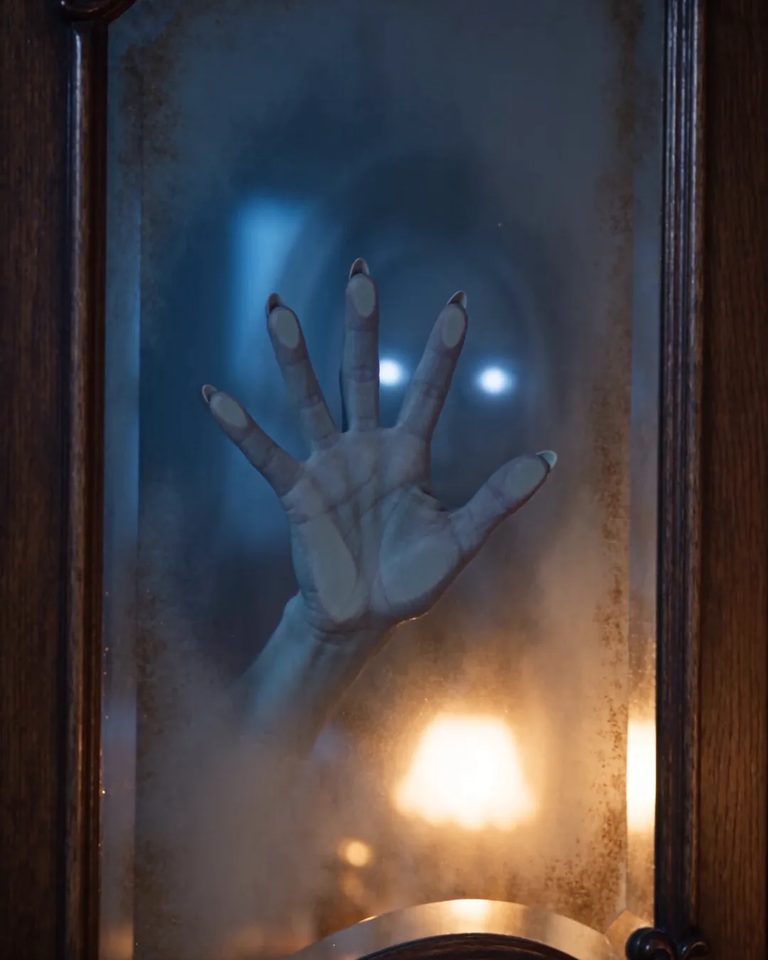 A ghostly hand pressed against the glass of a wardrobe door