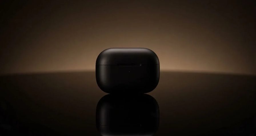 AI-generated cinematic product shot of a matte black earbud case on a dark reflective surface under a warm rim light